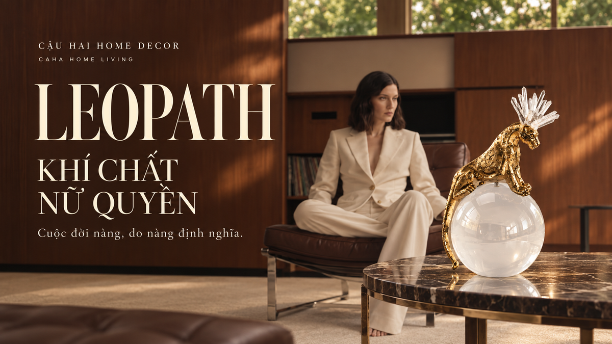 Banner Leopath – Khí chất nữ quyền: tượng báo sắc vàng trên quả cầu pha lê, bên người phụ nữ mặc suit kem trong không gian gỗ ấm.
